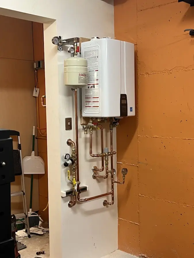 Plumbing technician inspecting water heater connections in Port Salerno